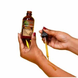 Jamica Mango & Lime Caster Oil lady demonstrates with droper