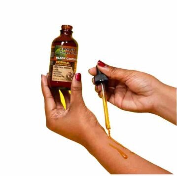 Jamica Mango & Lime Caster Oil lady demonstrates with droper